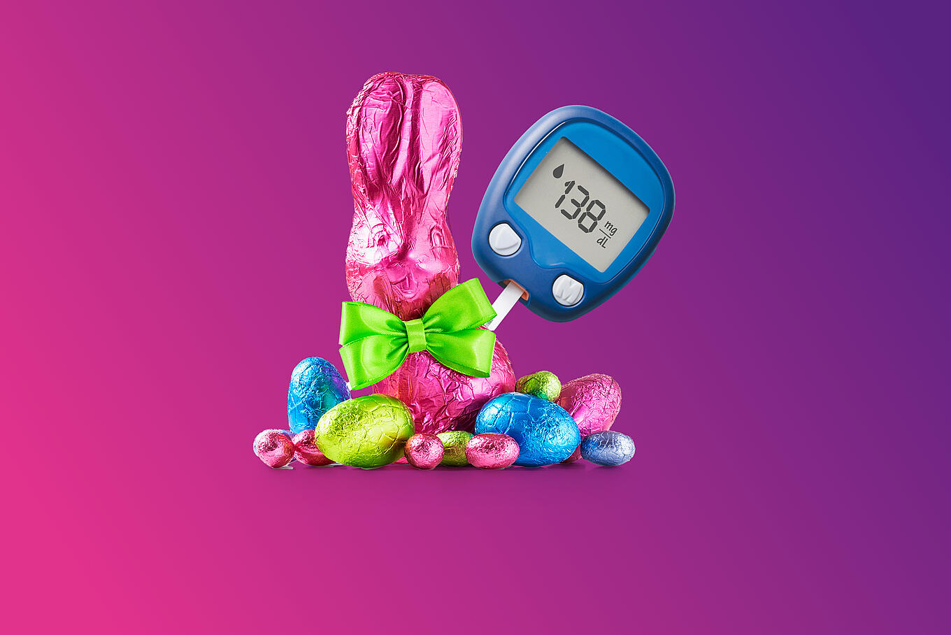 Schokoladen-Osterhase mit weiteren Schokoeiern und einem Diabetes-Messgerät