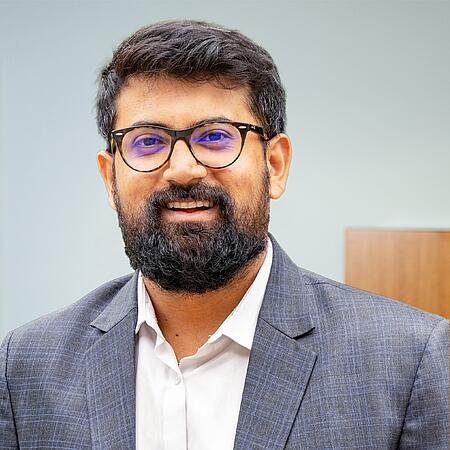 Bild eines dunkelhaarigen Mannes mit Brille und Bart.