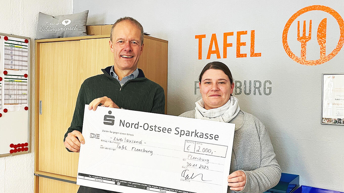 Juta-Pharma-Geschäftsführer Torben Jung Laursen überreicht einen symbolischen Check an die Leiterin der Tafel Flensburg.