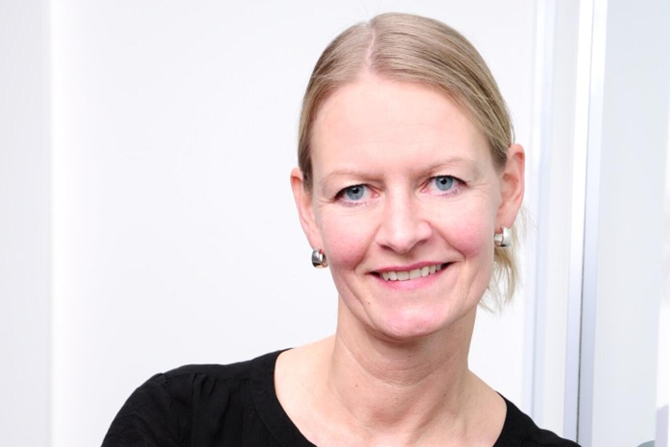 Portrait einer Juta-Pharma-Mitarbeiterin. Sie hat blonde Haare und trägt eine schwarze Bluse.